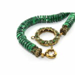 Necklace composed of natural malachite discs entirely threaded with knots. Antique gold treated brass & copper alloy pendant with glass cabochon stones, pearls and SWAROVSKI crystals.